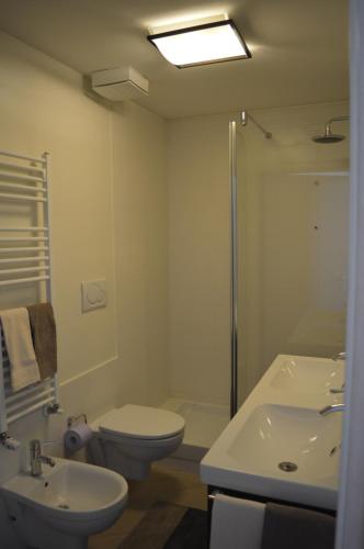 a bathroom with a toilet and a sink and a shower at La Lanterna Apartment in Genoa