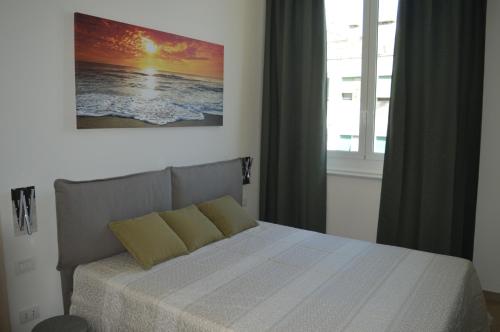 a bedroom with a bed with a picture on the wall at La Lanterna Apartment in Genova
