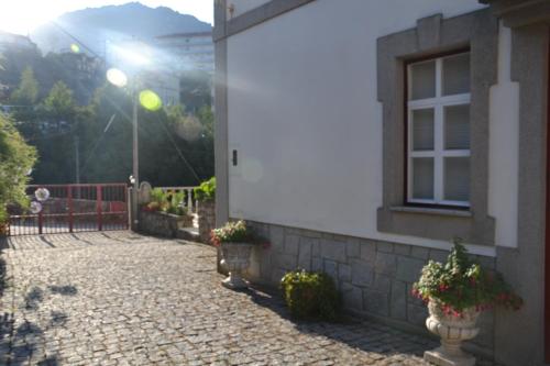 a building with potted plants next to a window at Casa da Ponte do Arrocho in Loriga