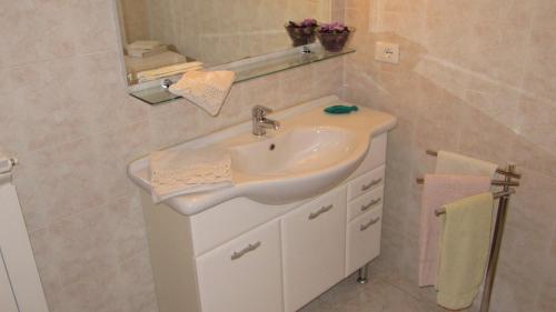 LuniにあるRose Apartmentのバスルーム(白い洗面台、鏡付)