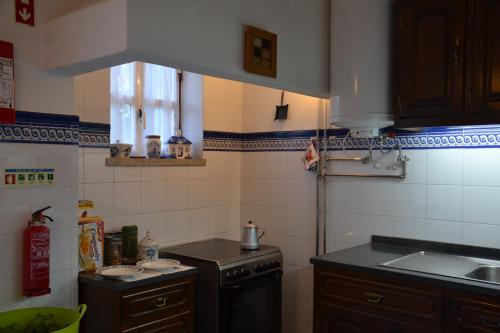 a small kitchen with a sink and a stove at Casa da Ponte do Arrocho in Loriga