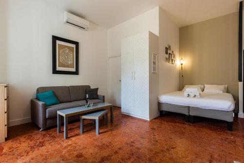- un salon avec un canapé et un lit dans une chambre dans l'établissement Chez Nous - 7 Appartements sur le Vieux Port, à Marseille