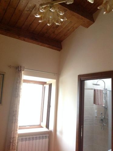 ein Bad mit einem Fenster und einer Decke in der Unterkunft La Dote in Santo Stefano di Sessanio