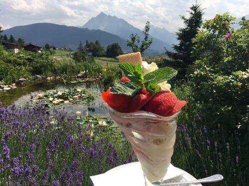 a ice cream cone with strawberries in a field of flowers at Hotel Restaurant Grünwalderhof in Innsbruck