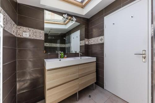 une salle de bain avec un lavabo et un miroir dans l'établissement Chez Nous - 7 Appartements sur le Vieux Port, à Marseille