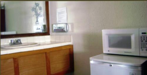a kitchen with a microwave and a sink at Hotel El Sausalito in Ensenada