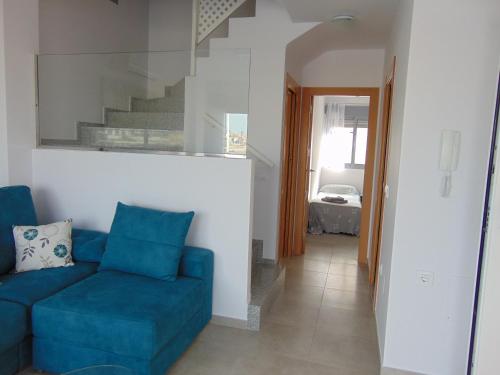 sala de estar con sofá azul y escaleras en Villa Vistamar, en Puerto de Mazarrón