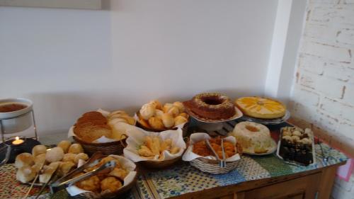a table with many different types of bread and pastries at Pousada Casa Pinha em Campos do Jordão in Campos do Jordão