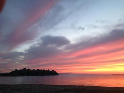 an island in the ocean with a sunset at Hotel Alexandros II in Toroni