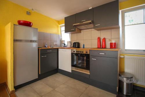 a kitchen with black and white appliances and a window at Bungalows am Grimnitzsee in Joachimsthal