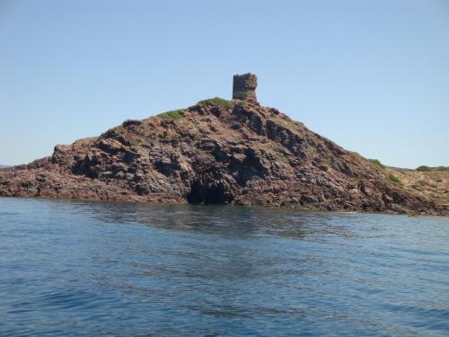 an island in the water with a lighthouse on it at Hotel Maison Tresnuraghes in Tresnuraghes