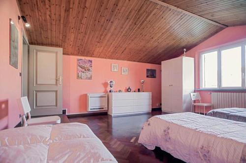 ein Schlafzimmer mit zwei Betten und einer Holzdecke in der Unterkunft Villa Parenti in Lucca