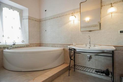 ein Badezimmer mit einer großen Badewanne und einem Waschbecken in der Unterkunft Villa Parenti in Lucca