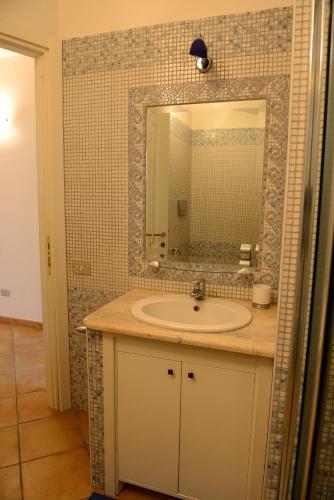 a bathroom with a sink and a mirror at Nuova Valmar Villa Condominio Rei Sole in Costa Rei