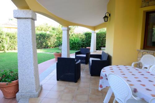 a patio with a table and chairs on a house at Nuova Valmar Villa Condominio Rei Sole in Costa Rei