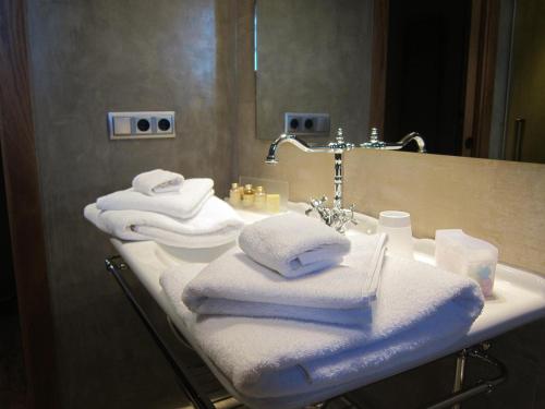 a bathroom with towels on a sink in front of a mirror at Hotel Rural Can Vila in Sant Esteve de Palautordera