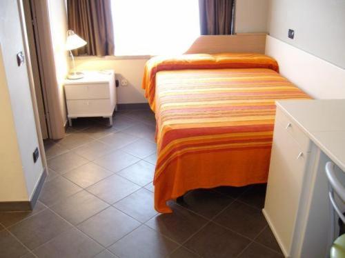 a hotel room with a bed with an orange blanket at Hotel Residenza Gra 21 in Rome
