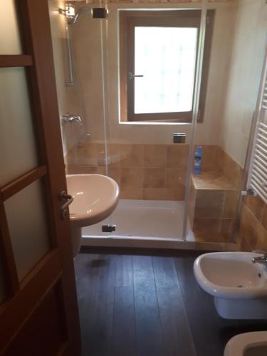 a bathroom with a tub and a sink and a shower at Villa Silvi piscina sauna e hot tub in Perledo