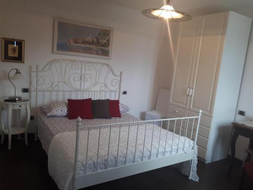 a bedroom with a white bed with red pillows at Villa Silvi piscina sauna e hot tub in Perledo