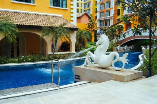 een standbeeld naast een zwembad in een gebouw bij Venetian Signature PoolView Resort Jomtian Pattaya in Jomtien Beach