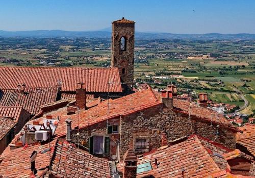 ein Gebäude mit einem Uhrenturm darauf in der Unterkunft Hotel Italia Cortona in Cortona
