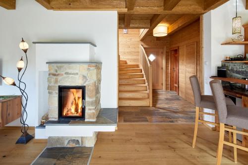 a living room with a fireplace and a staircase at Lehenriedl Chalet in Wagrain