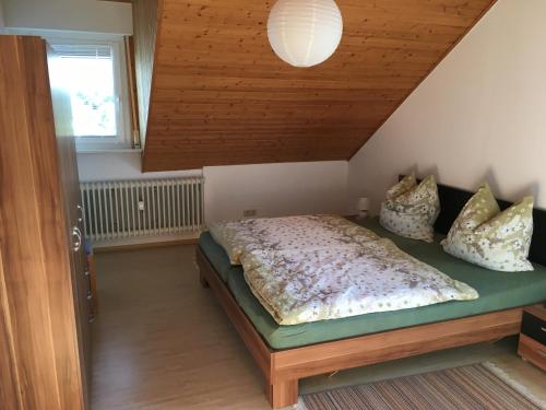 a bedroom with a bed with a wooden ceiling at Ferienwohnungen Hehner in Patersberg