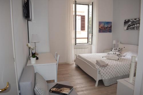 a white bedroom with a bed and a desk at My Bed Vatican Museum in Rome