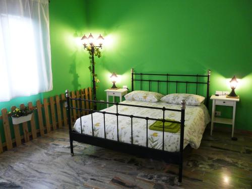 um quarto verde com uma cama e duas mesas de cabeceira em In Giardino B&B em Cassina deʼ Pecchi