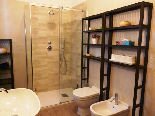 uma casa de banho com um chuveiro, um WC e um lavatório. em In Giardino B&B em Cassina deʼ Pecchi