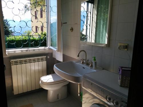 a bathroom with a sink and a toilet and a window at Casa Pierini in Civenna
