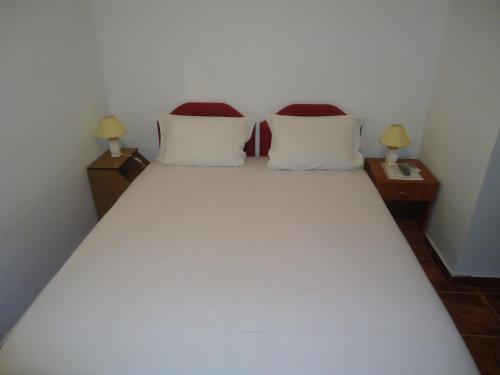 a bedroom with a white bed with two night stands at Apartments Raičević in Budva