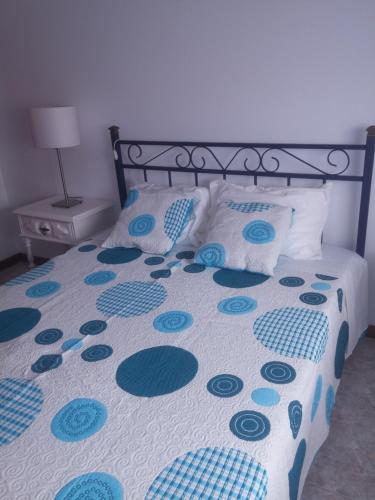 ガファーニャ・ダ・ヴァゲイラにあるCasa Carmoのベッド(青と白のシーツ、枕付)