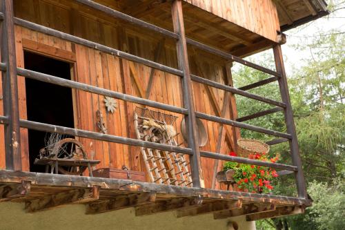 a window of a wooden house with flowers on the balcony at Villa Ortensia in San Vigilio Di Marebbe