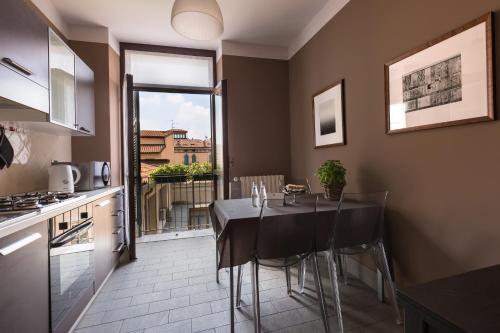 eine Küche mit einem Tisch mit Stühlen und einem Fenster in der Unterkunft Escalus Luxury Suites Verona in Verona