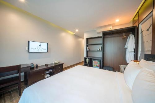 a bedroom with a bed and a desk and a tv at Dai An Phu Villa in Hoi An