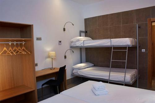 a room with two bunk beds and a desk at The Book Factory Hostel in Valladolid