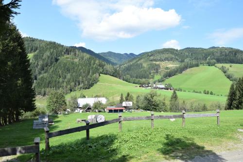 a field with a fence and green hills at Ferienhaus Dirnbacher Hütte in Turnau