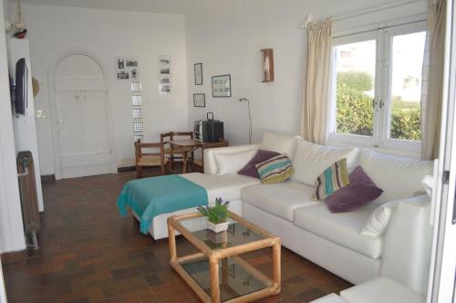 uma sala de estar com um sofá branco e uma mesa em Los Sargos em Punta del Este