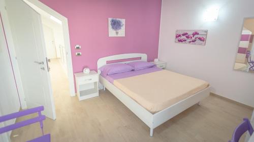 a small bedroom with a bed with purple walls at Villa Patrizia Selinunte in Marinella di Selinunte