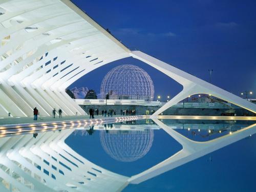 un edificio con un reflejo en el agua por la noche en Casa Isa en Valencia