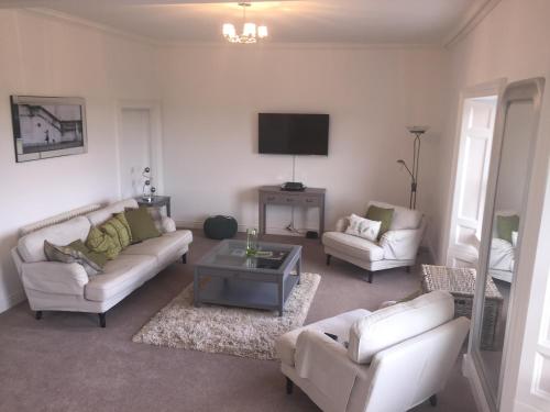 a living room with two white couches and a tv at 3 Frenchgate House in Richmond