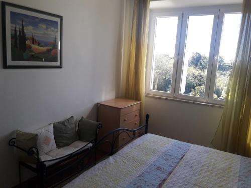 een slaapkamer met een bed en een stoel naast een raam bij Apartment Pavlito in Dubrovnik