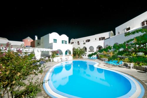 una piscina en un complejo por la noche en New Haroula, en Fira