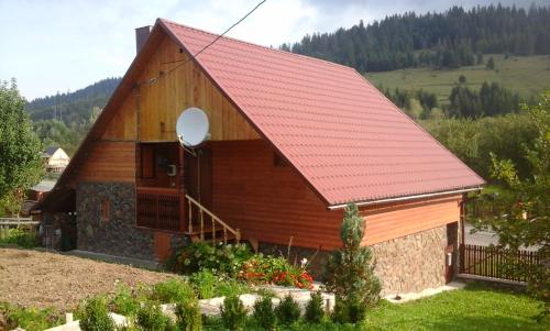ein kleines Holzgebäude mit rotem Dach in der Unterkunft Anastasiya in Izky