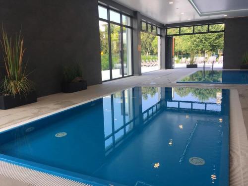 a swimming pool in a house with blue water at Przystań Koło Brzegu in Kołobrzeg