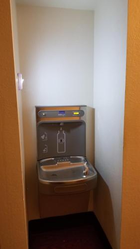 a small bathroom with a toilet in a wall at Super 8 by Wyndham St. Cloud in Saint Cloud
