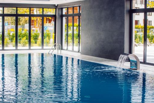 a swimming pool with a fountain in a building at Przystań Koło Brzegu in Kołobrzeg