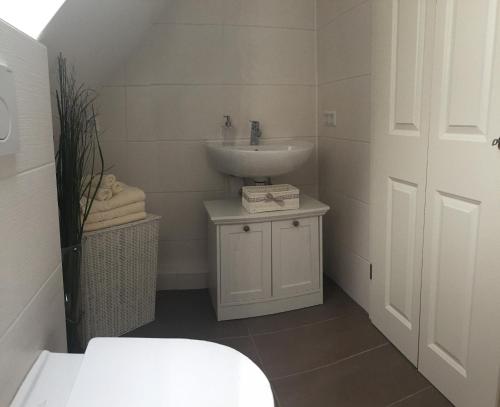 a white bathroom with a sink and a toilet at Joel Living in Hannover
