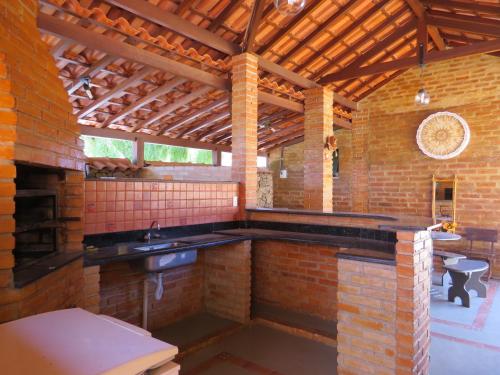 a brick kitchen with a sink and a brick wall at Chalé da Serra in São João del Rei